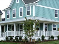 <b>Round Vinyl Columns with decorative touches and white vinyl railing attached to composite porch flooring and lattice under the porch</b>