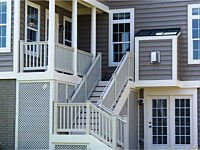 <b>White round columns with white vinyl railing on porch and steps. White vinyl lattice underneath porch and stairs</b>