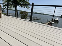 <b>A great combination for an unobstructed water view. TimberTech Azek Vintage Collection deck boards in the color of Coastline with Ultralox black aluminum railing with horizontal cable rail.</b>