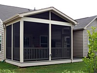 <b>Screened Porch with a gable style roof, complete with composite deck boards and tan vinyl railing and balusters. You can see an electrical outlet was installed on the exterior of the structure for ease in accessing power when outside of the home.</b>
