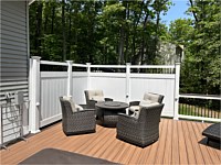 <b>Here are white vinyl privacy panels built onto the deck to give the homeowners more privacy. Panels include a black aluminum topper and eyeball lights on the posts that integrate seamlessly into the look of the panels. Trex composite deck boards in the color of Tiki Torch with a Lava Rock feature board.  The railing is white PVC vinyl with a Lava Rock drink rail and black aluminum balusters.  Eyeball post lights on the railing to light up the space during the evening hours.f</b>