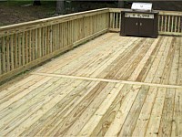 <b>Pressure treated wood deck with breaker board in the middle of the deck, wood railing</b>
