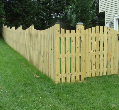 Spaced Picket Wood Fence with a Concave Dip and an Arched Gate