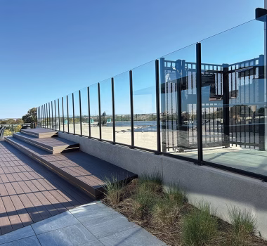 Roof top composite decking, custom glass panel fencing around pool, and aluminum control access gate to multifamily condo building in Virginia