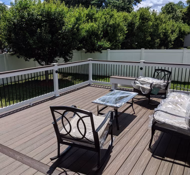 Trex Transcend Spiced Rum Deck Boards with White Lincoln Vinyl Railing Black Round Aluminum Balusters and matching cocktail rail + black eyeball lights in Ellicott City MD