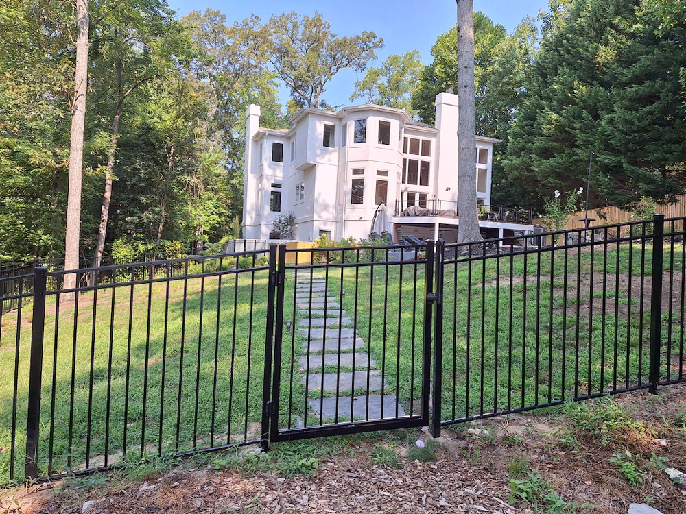 front of house with black aluminum fence and gate