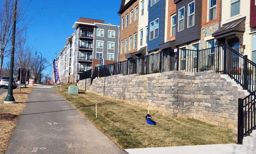 commercial builder community townhomes with a fence on a retaining wall