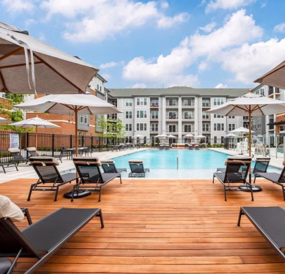 beautiful wood deck on the side of a pool at a commercial property