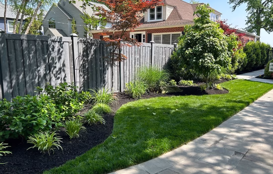 gray vinyl fence with beautiful landscaping