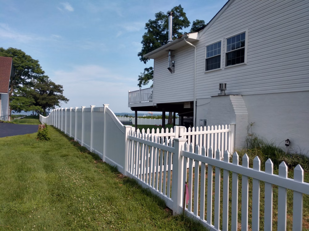 beautiful privacy fence that meets a white vinyl picket fence