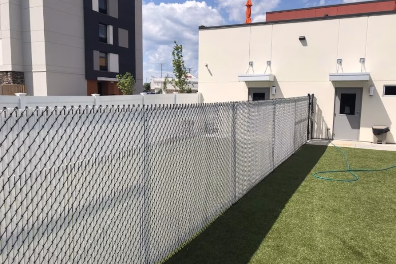 Chain Link Interior Fence with White Slats and White Vinyl Privacy Fence at Dog Kennel